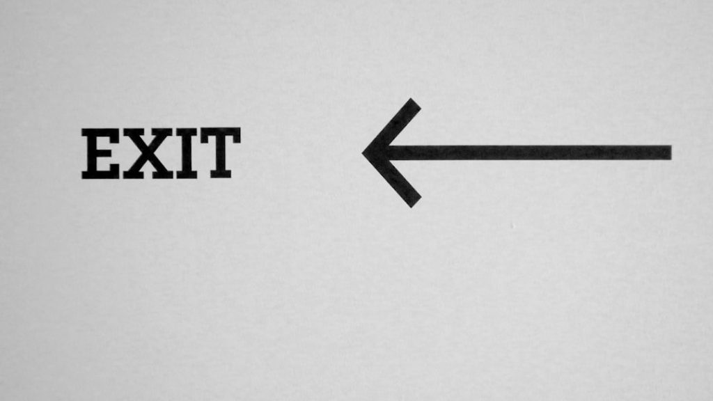 Uma Foto Em Preto E Branco De Um Sinal De Saida F6cMi3DXdPg