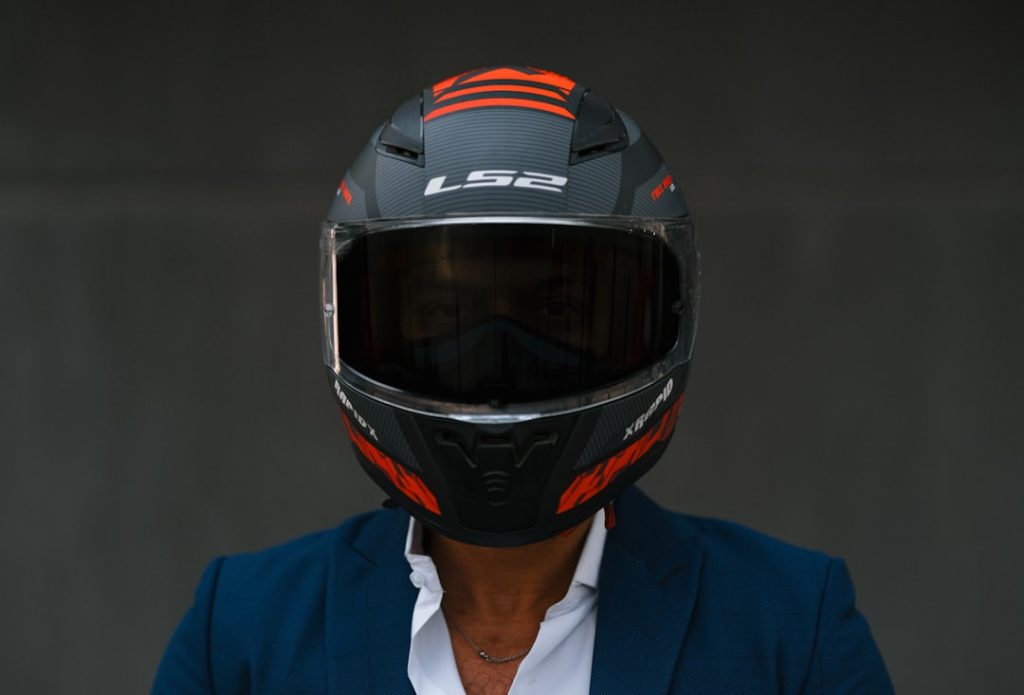 Um Homem Usando Um Capacete De Motocicleta E Uma Jaqueta Azul Y eYPnVy7Ms