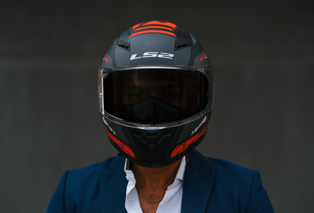 Um Homem Usando Um Capacete De Motocicleta E Uma Jaqueta Azul Y eYPnVy7Ms