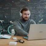 Homem Usando Fones De Ouvido Trabalha No Laptop No Escritorio JrcPePK_dEM