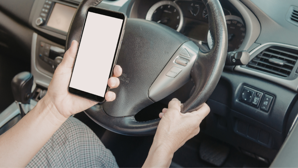 Mulher utilizando o aparelho celular enquanto dirige.