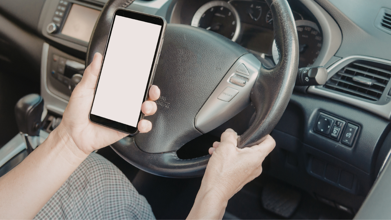 Mulher utilizando o aparelho celular enquanto dirige.