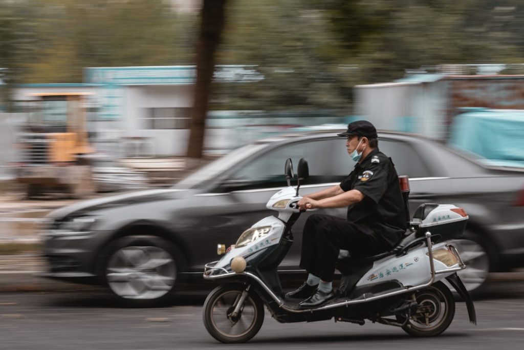 Um Policial Andando De Moto Por Uma Rua jydoSjryOIQ