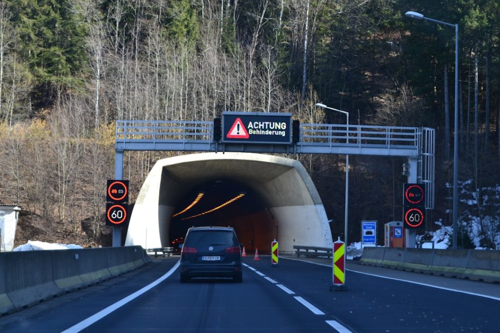 Carro Se Aproximando Da Entrada De Um Tunel Com Placas De Alerta VEM1 8X6ZcM