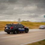 Carro Da Policia Dirigindo Numa Rodovia Com Fundo Borrado gZbUqVZXOus