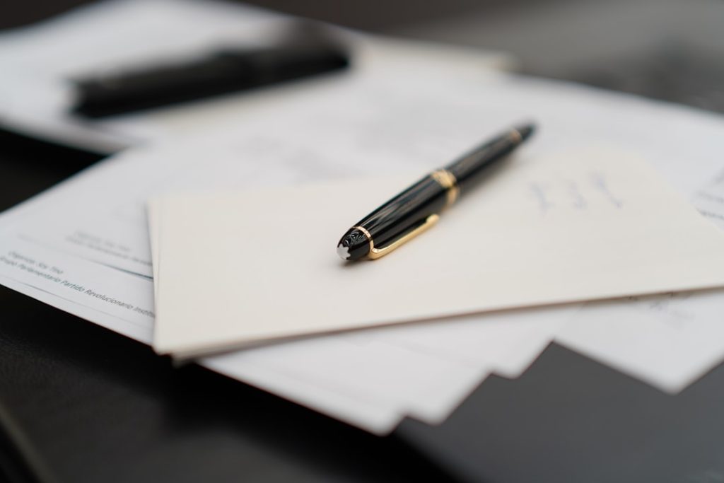 Uma Caneta Sentada Em Cima De Uma Pilha De Papeis D8 78LclvmQ