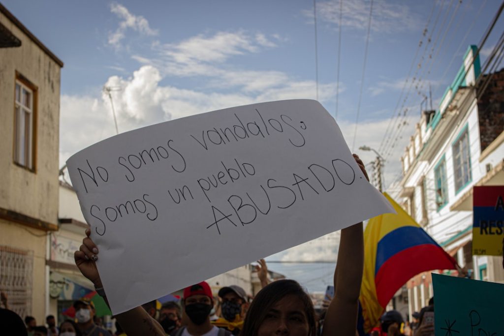 Uma Mulher Segurando Um Sinal Em Uma Multidao jZKTi9J7tBg