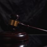 Um Martelo De Madeira Repousa Sobre Uma Superficie Escura T69Smz0SJ6w