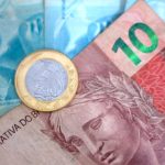 Um Close up De Uma Conta De Dinheiro Com Uma Moeda Em Cima Dela gK whGsF0iY