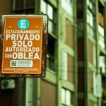 Um Sinal Em Um Poste Na Frente De Um Edificio FzUtAGOVLK4