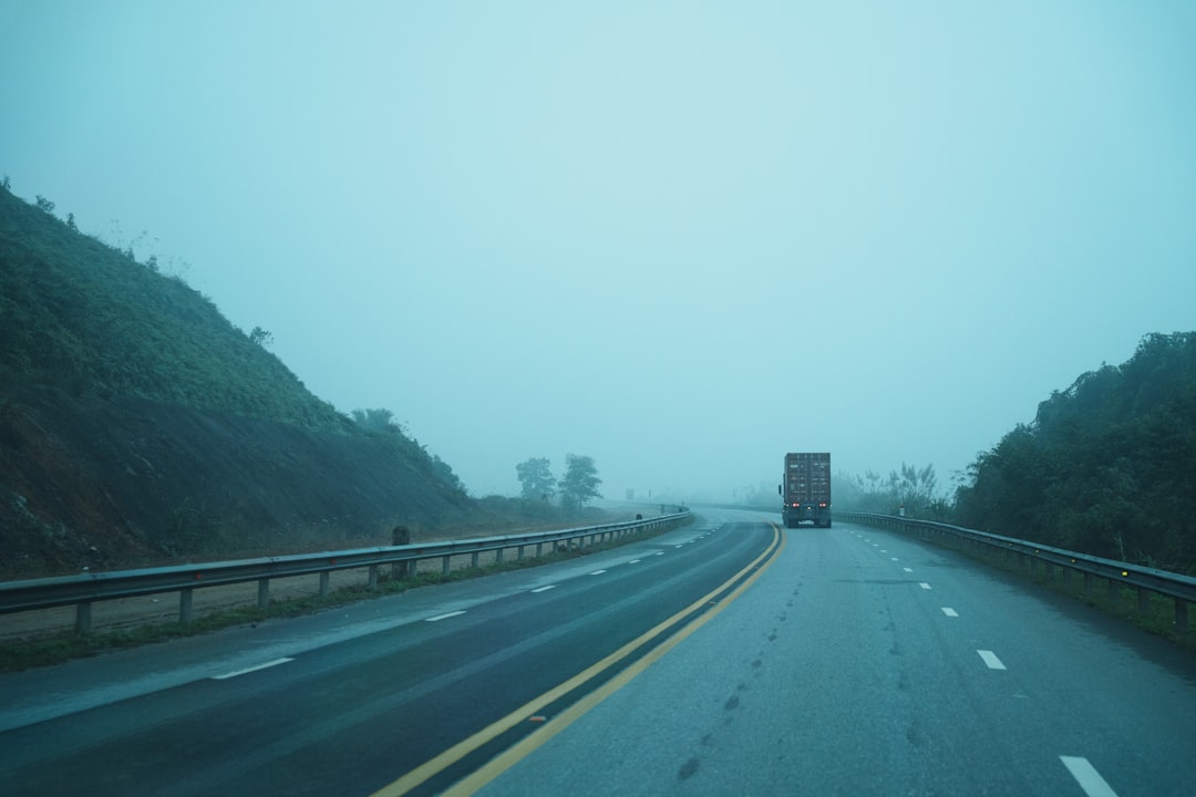 Um Caminhao Passa Por Uma Estrada Enevoada Entre Colinas jBPUR0Xn7O4