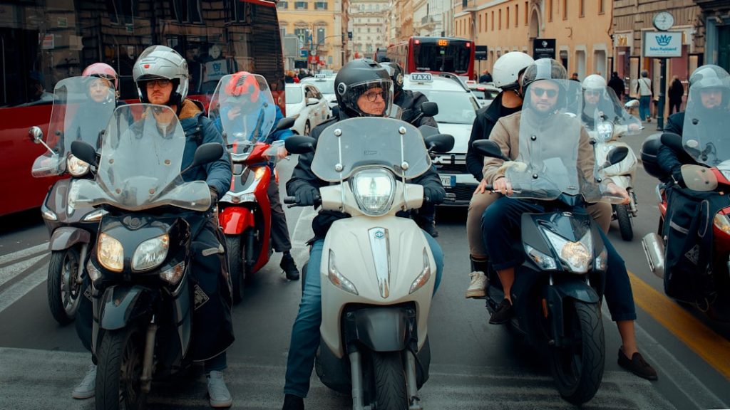 Grupo De Pessoas Andando De Scooter Em Uma Rua Da Cidade MJovgGNJ_Sg