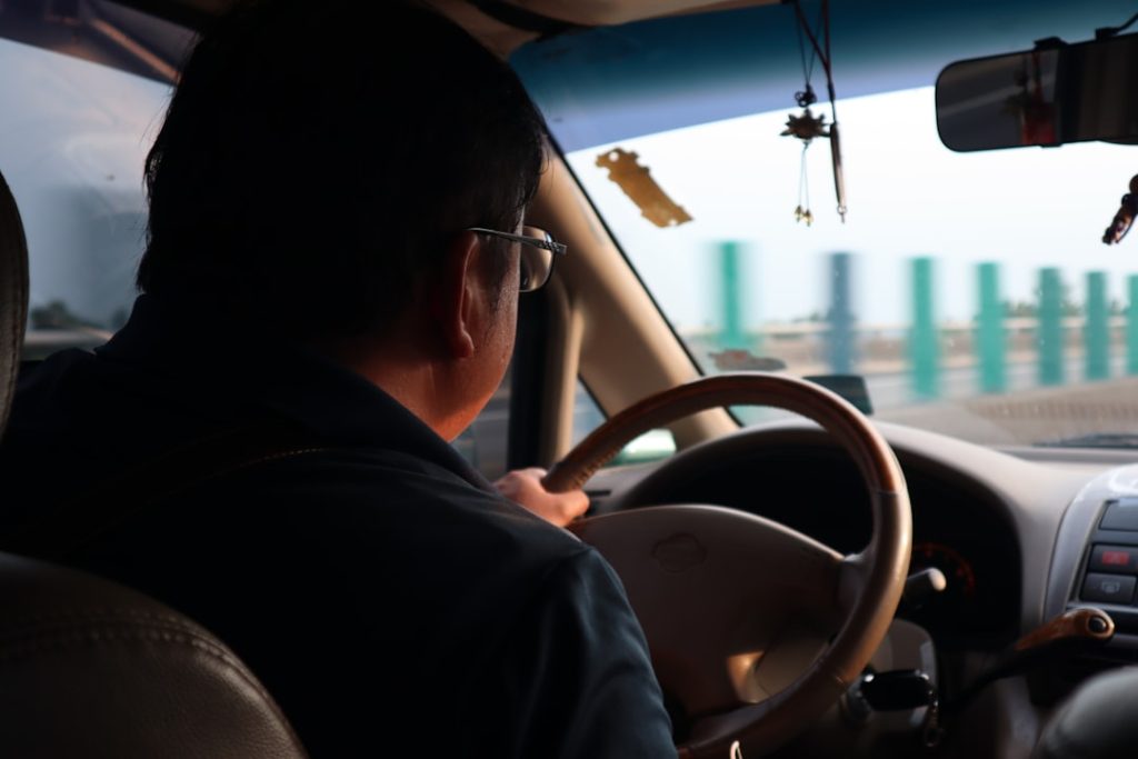 Homem Na Camisa Preta Que Conduz O Carro Durante O Dia 1E03pxFYPAE