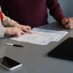 Duas Pessoas Revisando Documentos Em Uma Mesa MhqUBTxQ3Hw