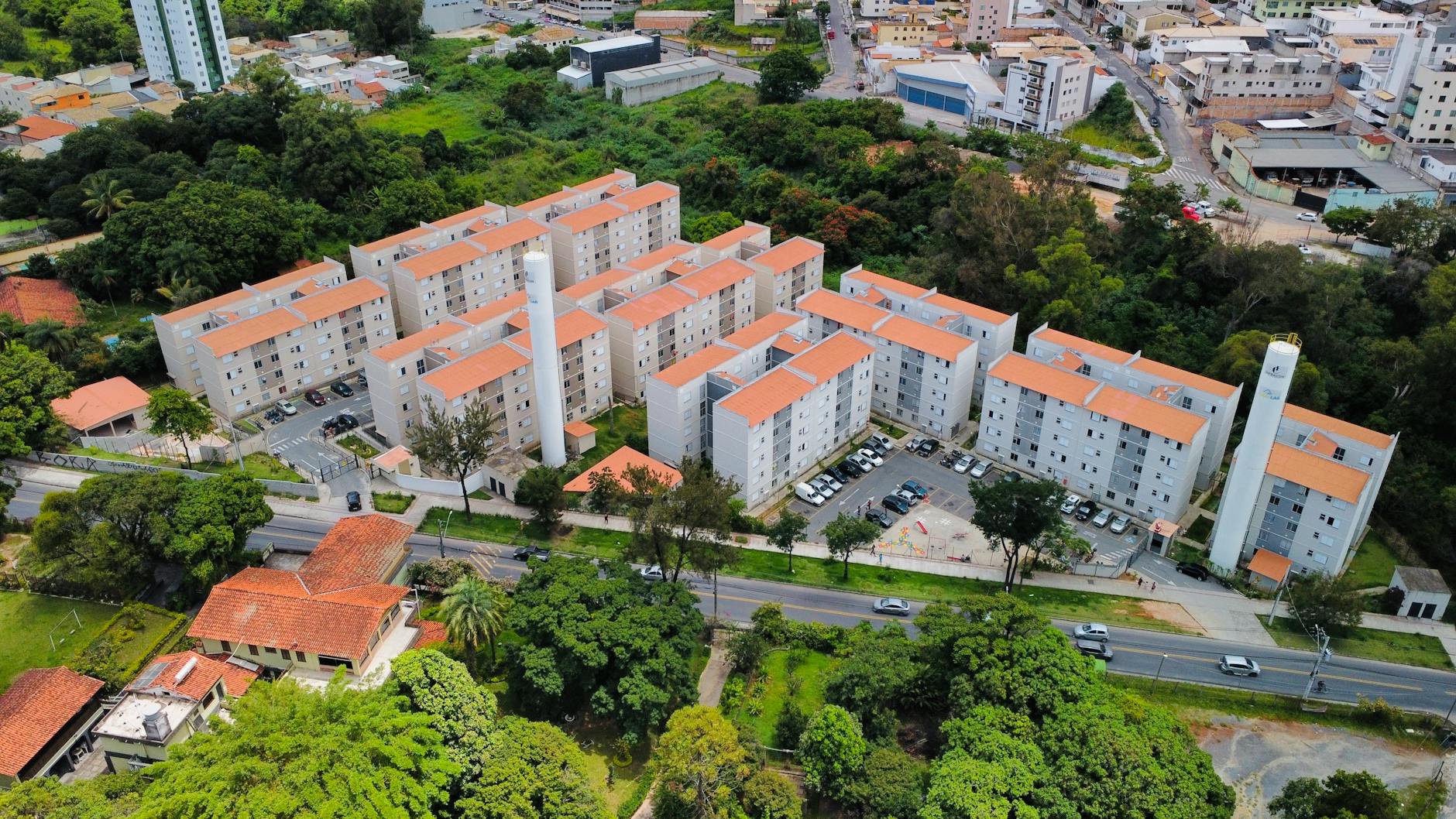 Aerial view showcasing a modern apartment complex surrounded by greenery in MG, Brazil.