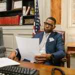 A lawyer attentively reviewing documents at his desk in a law office setting.