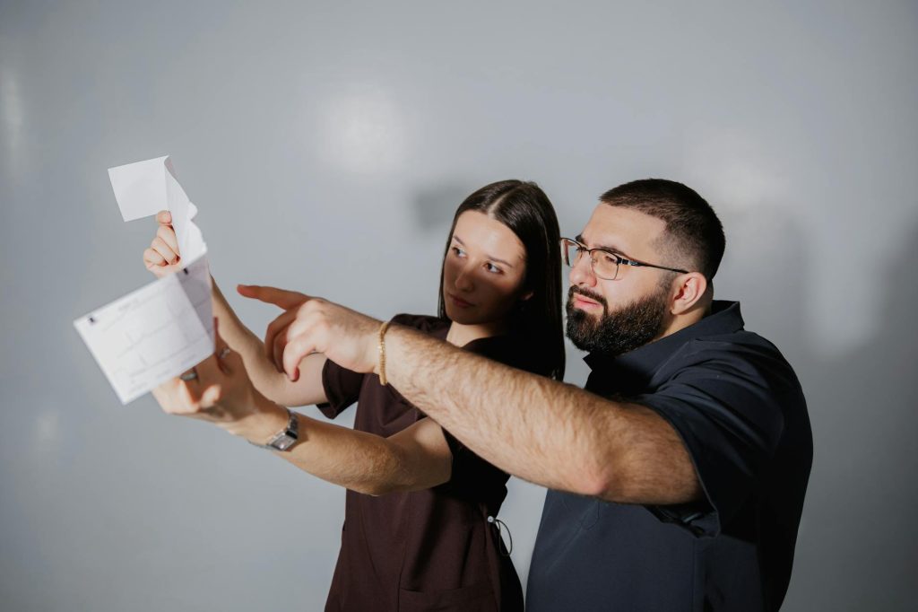 Two adults discussing and pointing at documents with focus and collaboration indoors.