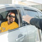 A police officer stops a driver for a traffic violation on a sunny day.