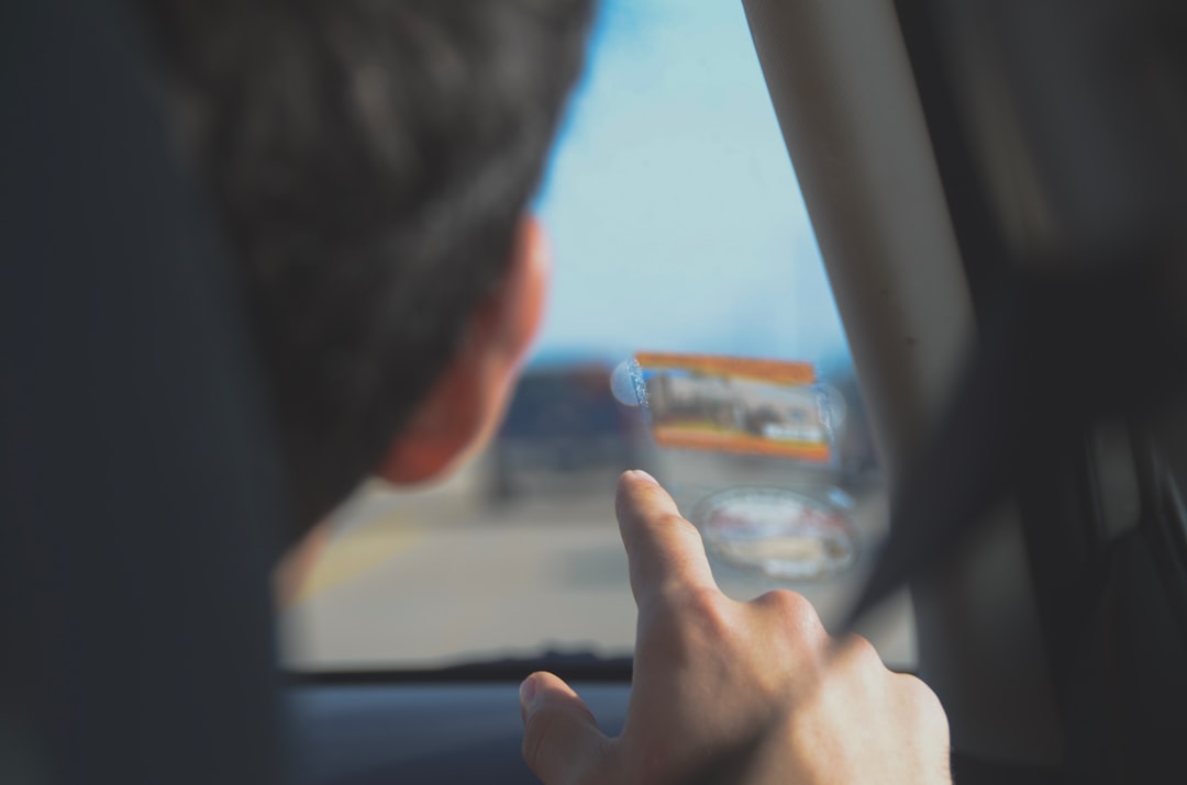 Um Homem Dirigindo Um Carro Enquanto Segura Um Telefone Celular Hi6URYMo6R4