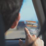 Um Homem Dirigindo Um Carro Enquanto Segura Um Telefone Celular Hi6URYMo6R4