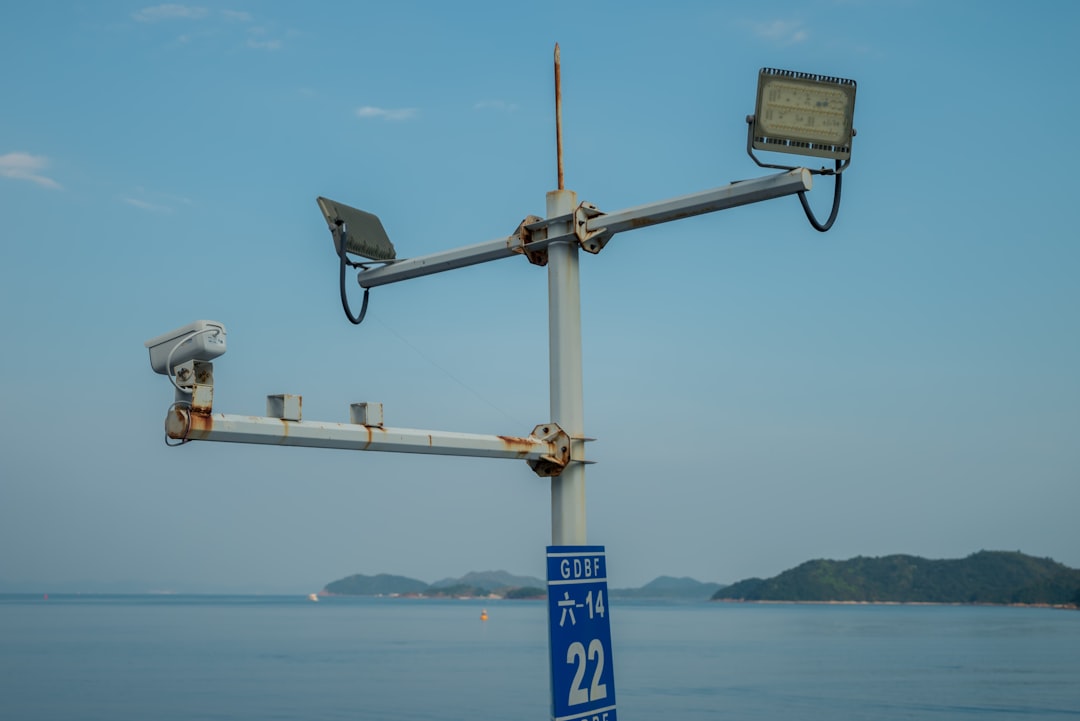 Um Par De Cameras Em Cima De Um Poste De Metal CShc3gnDCtc