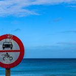 Um Sinal Vermelho E Branco Sentado Ao Lado De Uma Praia P_45f NQMDc