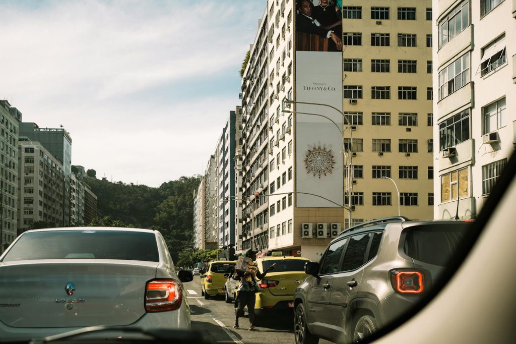 Busy city street in Rio de Janeiro featuring cars and tall buildings under a clear sky.