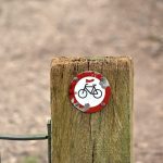 Um Poste De Madeira Com Uma Placa De Bicicleta QSfgSdp7UcU