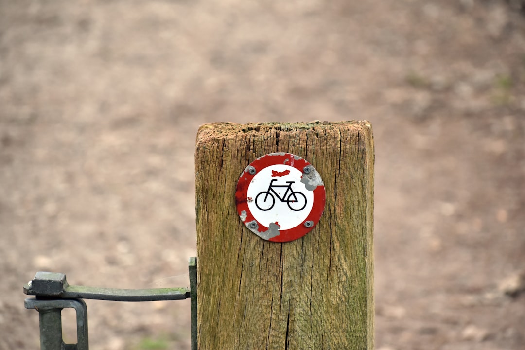 Um Poste De Madeira Com Uma Placa De Bicicleta QSfgSdp7UcU