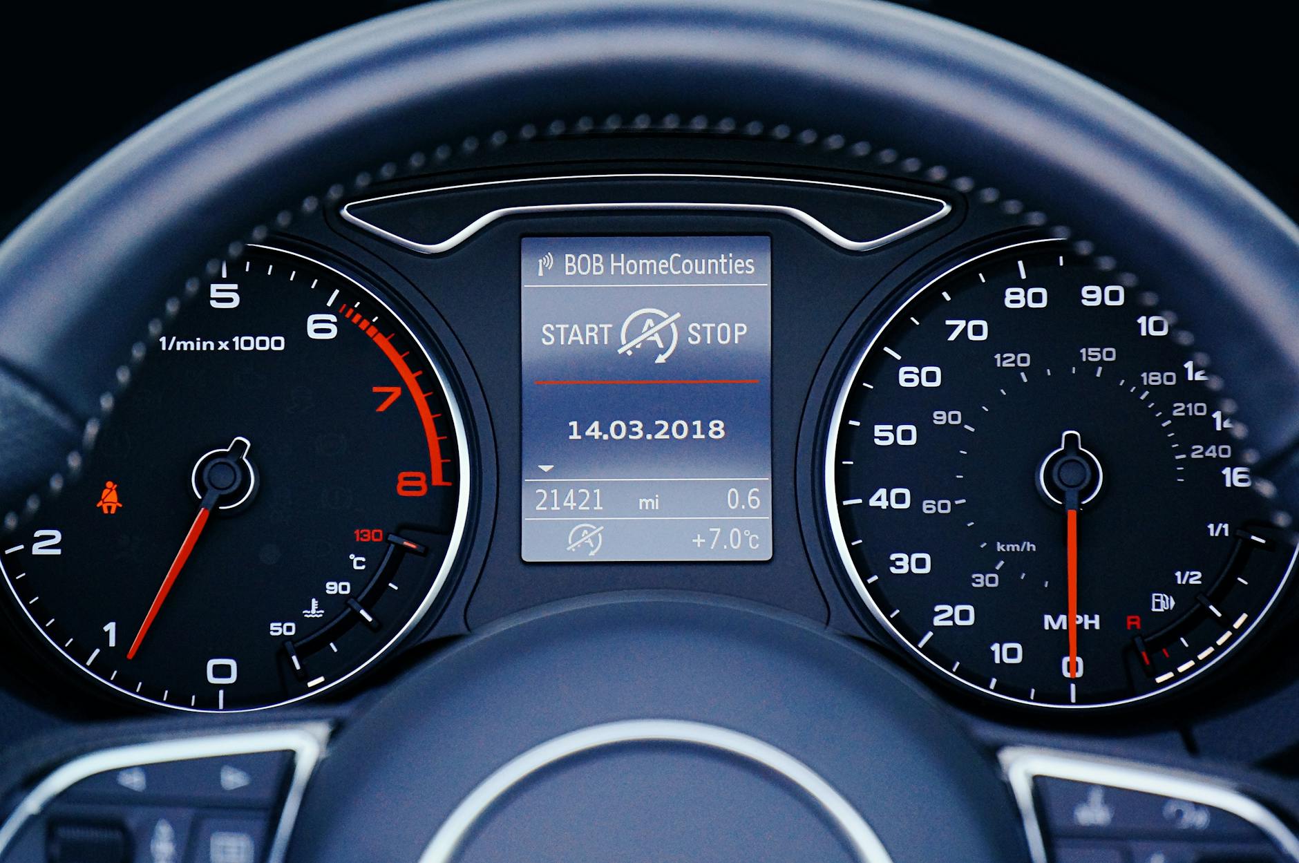 Close-up of a car dashboard displaying speedometer, tachometer, and digital display with mileage.
