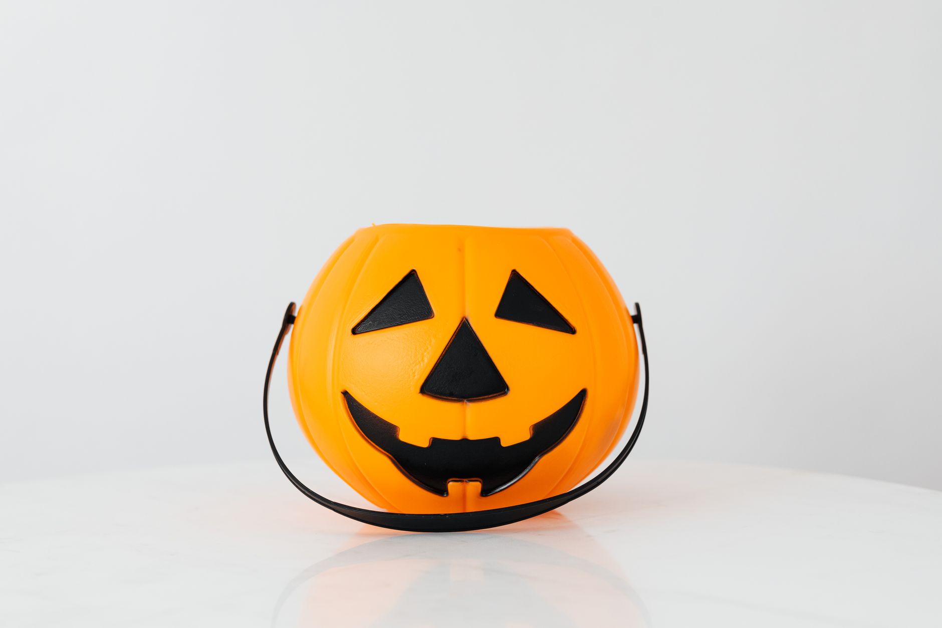 Bright orange pumpkin bucket for Halloween, perfect for trick-or-treat candy collection.