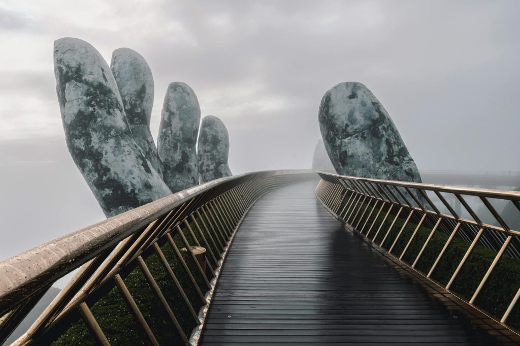The Golden Bridge in Da Nang, Vietnam, enveloped in fog, showcasing its iconic giant hands.