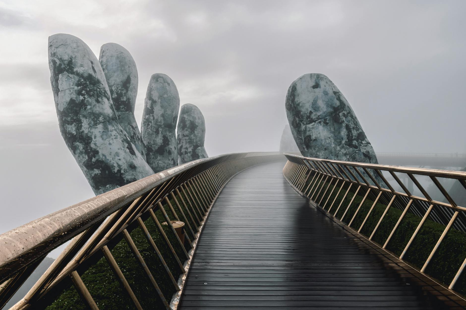The Golden Bridge in Da Nang, Vietnam, enveloped in fog, showcasing its iconic giant hands.