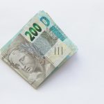 Stack of 200 Brazilian Real banknotes isolated on a white surface, symbolizing wealth and finance.