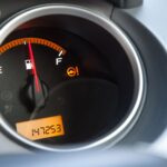 Detailed close-up of a car's fuel gauge with odometer showing a reading of 147253 miles.