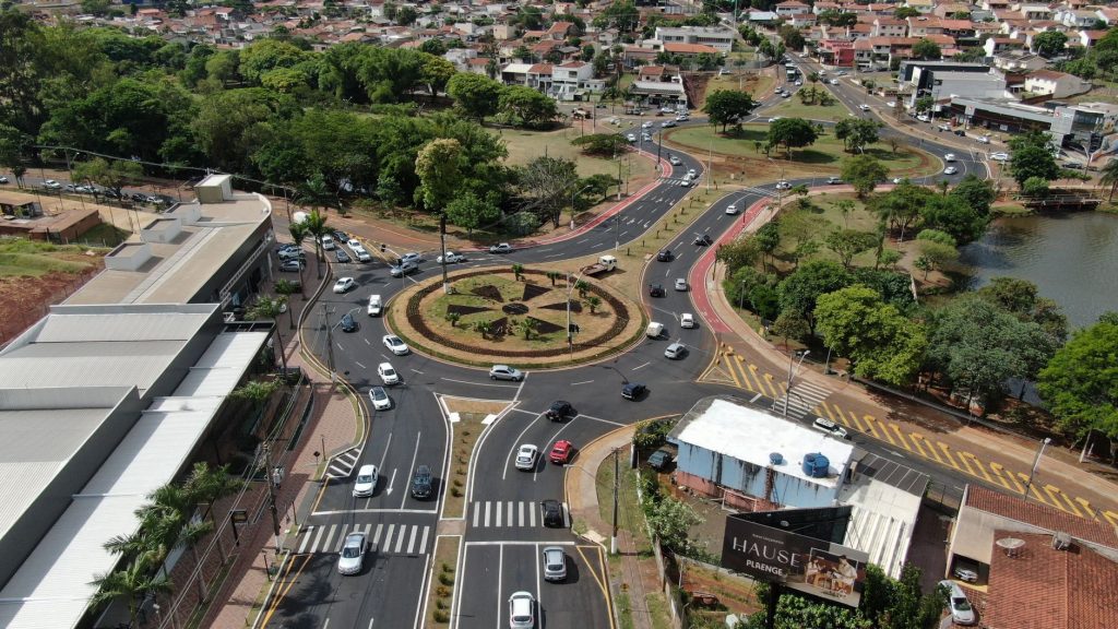 Aerial view of a busy roundabout in Gleba Fazenda Palhano, Brazil, surrounded by greenery and houses.
