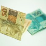 A close-up shot showcasing Brazilian banknotes, featuring 50 and 100 real bills.