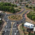 Aerial view of a busy roundabout in Gleba Fazenda Palhano, Brazil, surrounded by greenery and houses.