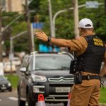 Police officer directing traffic on a busy street in Londrina, Brazil.
