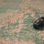 A miniature black car on a detailed map of Scandinavia, symbolizing travel adventures.