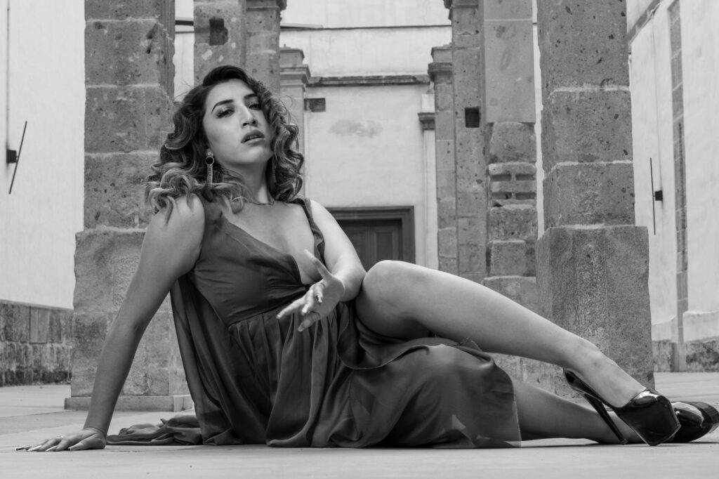 Black and white portrait of an elegant woman in a gown posing among historic architecture in Ciudad de México.