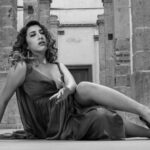 Black and white portrait of an elegant woman in a gown posing among historic architecture in Ciudad de México.