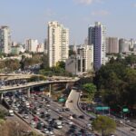 Aerial view of a bustling expressway and urban skyline in São Paulo, Brazil.