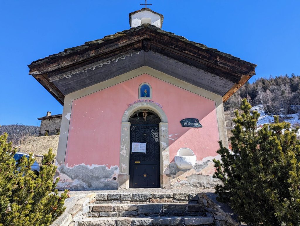 Charming small chapel in Sainte-Foy-Tarentaise, Auvergne-Rhône-Alpes, France, under a clear blue sky.