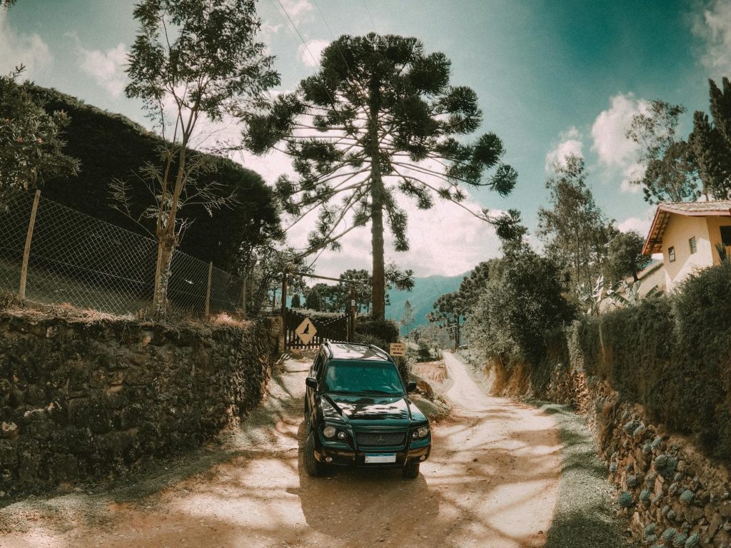 Black SUV parked on a scenic dirt road surrounded by nature in São Bento do Sapucaí, Brazil.