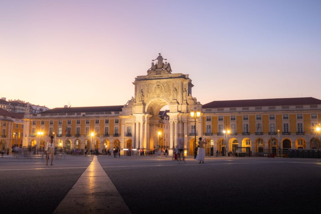 Scenic view of Arco da Rua Augusta in Lisbon during twilight with a vibrant sky.