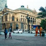Street view of São Paulo Municipal Theatre with pedestrians and workers in Sao Paulo.