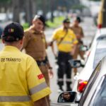 Traffic agent in bright uniform managing vehicles on a busy Londrina street.