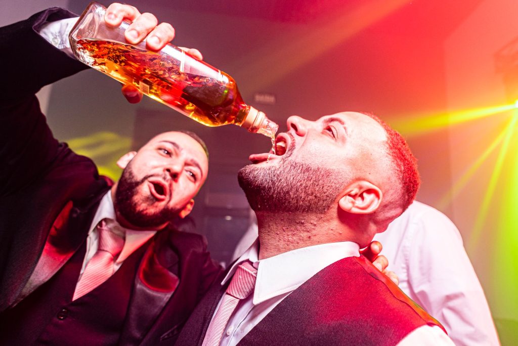 Vibrant nightlife party with men celebrating and pouring drinks.