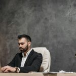 Focused professional man in an office environment working on a laptop.